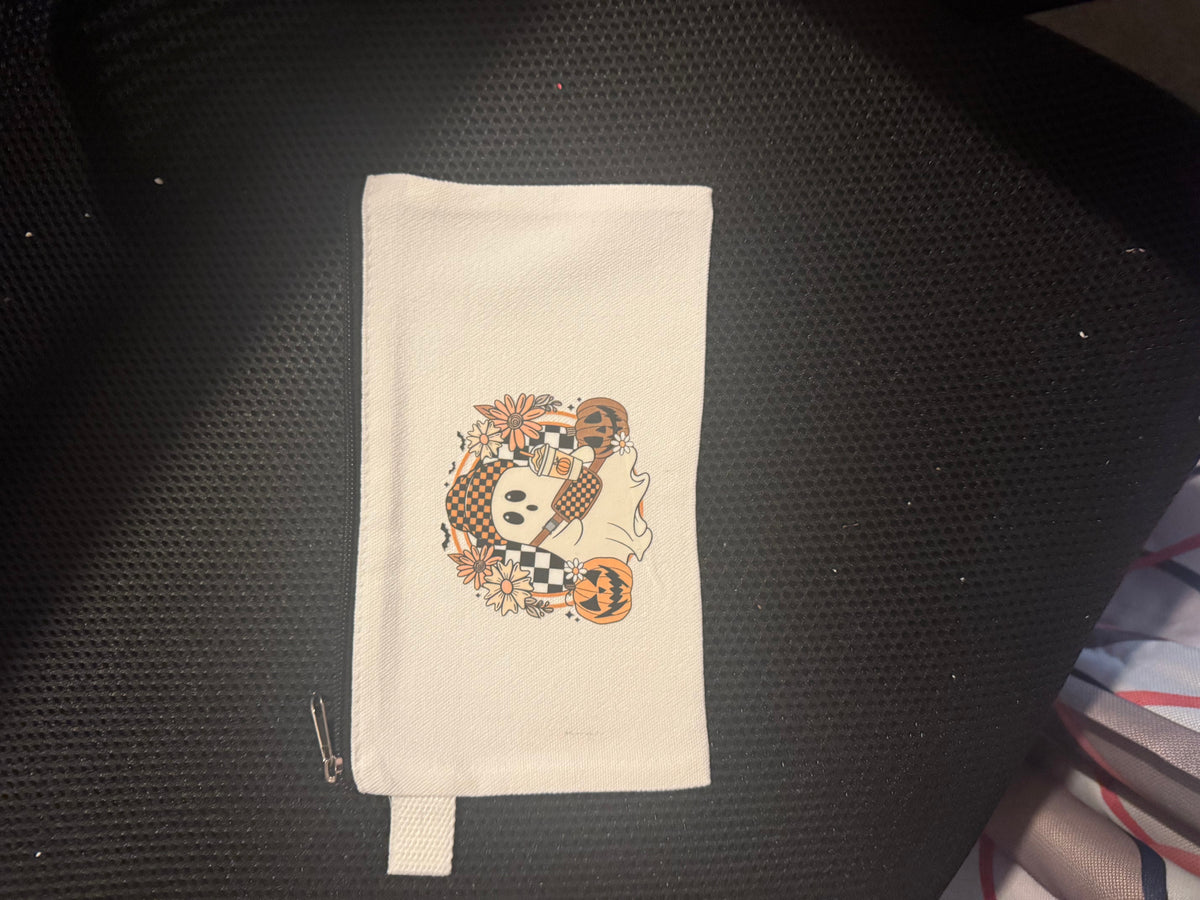 Cream canvas Halloween zipper pouch with ghost, pumpkins, flowers, and checkerboard artwork