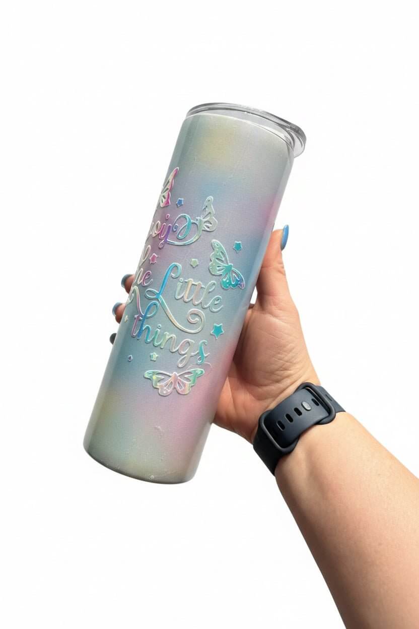 Handmade holographic stainless steel tumbler with butterfly design and inspiring quote, held in a hand.