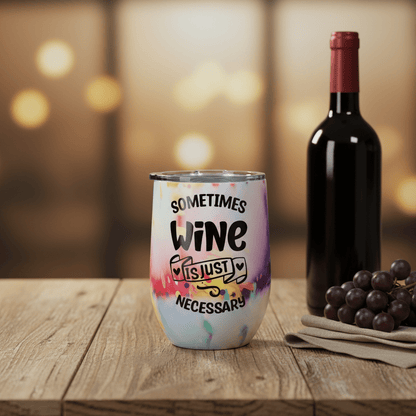 Colorful handmade wine tumbler 12 oz with 'Sometimes Wine Is Just Necessary' design beside a wine bottle.