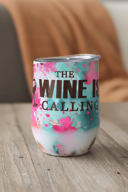 Handmade stainless steel wine tumbler featuring floral design and bold saying 'The Wine Is Calling'.