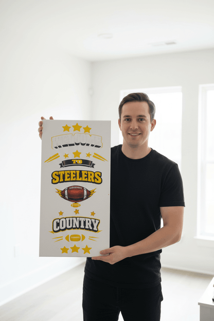 A person holding a handmade canvas sign that reads 'Welcome to Steelers Country' showcasing black and gold design elements.