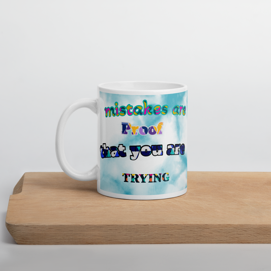 Ceramic mug with colorful text saying 'Mistakes are proof that you are trying', perfect for coffee or tea lovers.