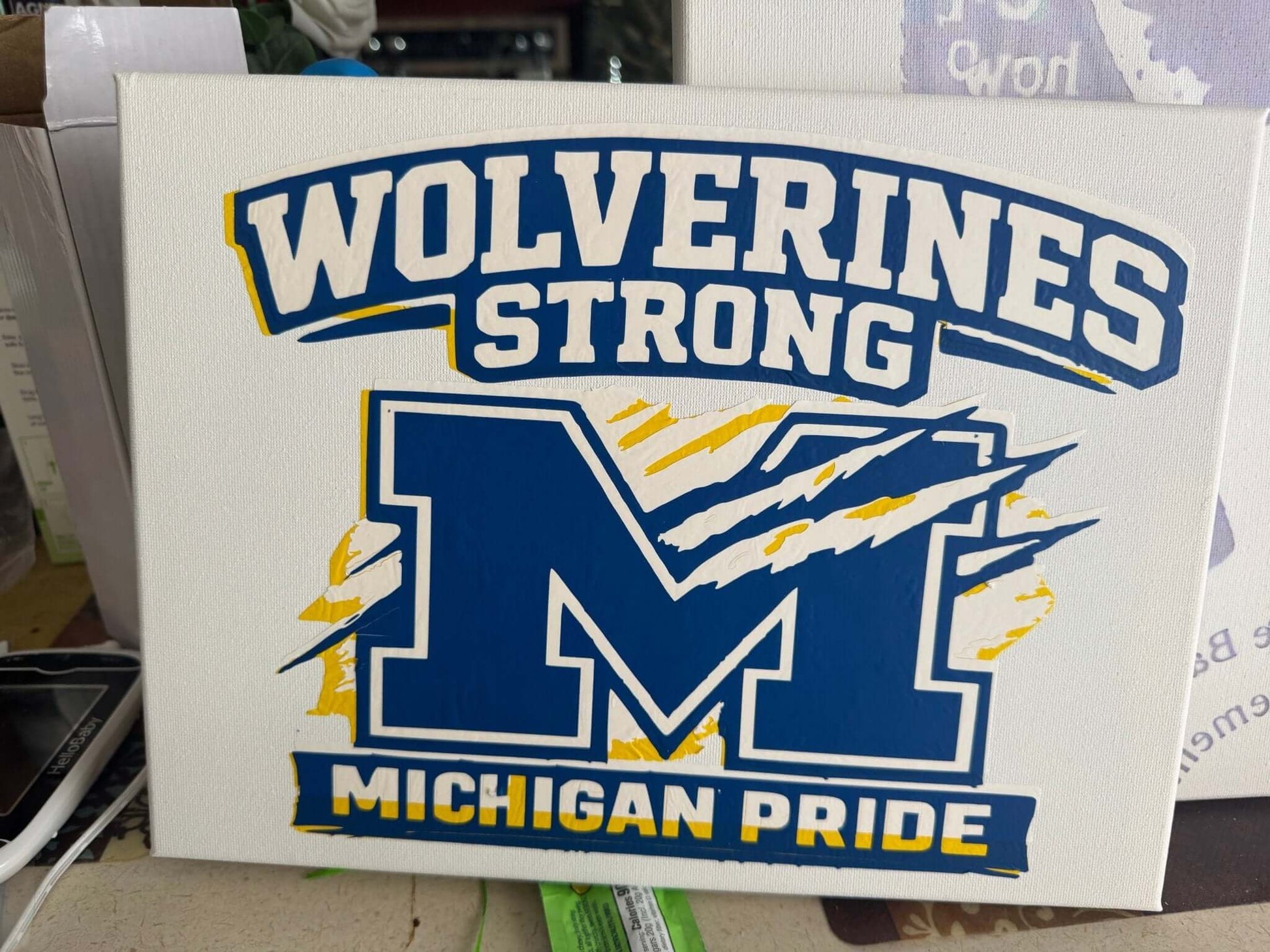 Wolverines Strong Michigan Pride Canvas Sign featuring a blue 'M' with claw marks on a white background.